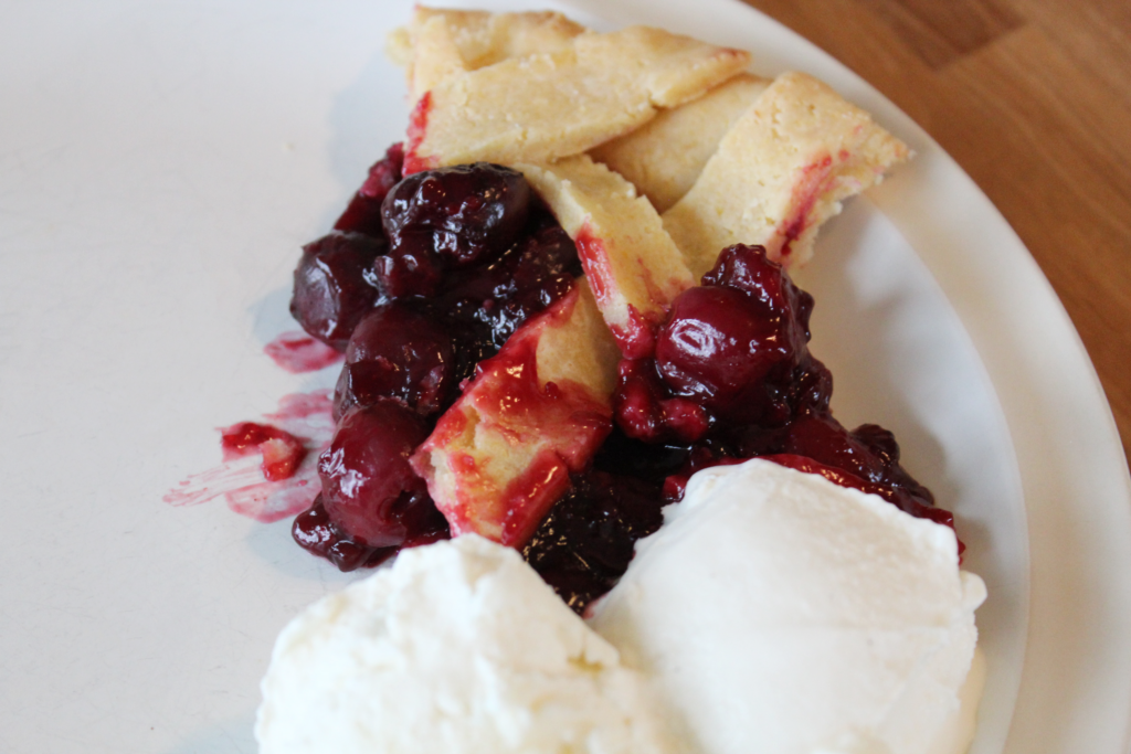 slice of cherry pie with two scoops of ice cream