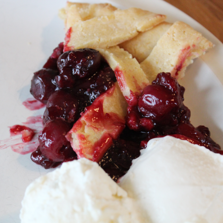 slice of cherry pie with two scoops of ice cream